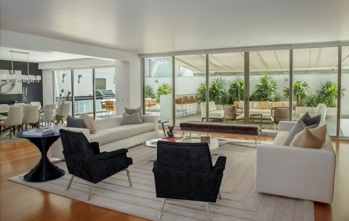 Living room, dining room, and patio with greenery in a house